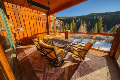 a patio with a table and chairs on a porch at Mill Creek 201 by SummitCove Lodging in Keystone