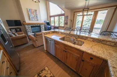 a kitchen with a sink and a living room at Ironwood 2996 by SummitCove Lodging in Keystone