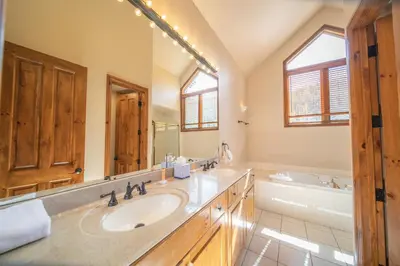 a bathroom with two sinks and a large mirror at Ironwood 2996 by SummitCove Lodging in Keystone