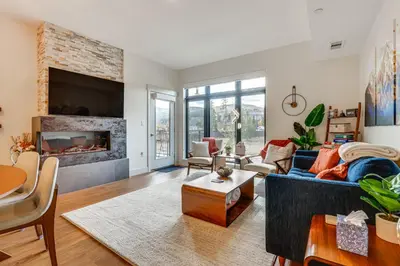 a living room with a couch and a fireplace at Mountain-View Condo in Downtown Winter Park! in Winter Park