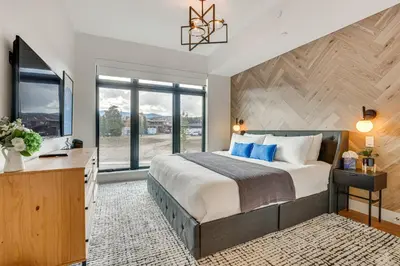 a bedroom with a large bed and a large window at Mountain-View Condo in Downtown Winter Park! in Winter Park