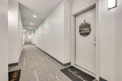 a hallway with white walls and a plant in a pot at Mountain-View Condo in Downtown Winter Park! in Winter Park