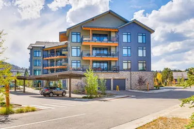 an apartment building with a car parked in a parking lot at Mountain-View Condo in Downtown Winter Park! in Winter Park