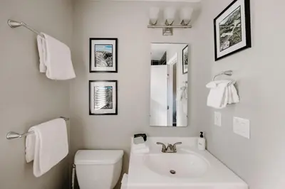 a bathroom with a sink and a toilet and a mirror at Alpine Hideaway with Free Shuttle - Wildernest in Silverthorne