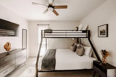 a bedroom with a bunk bed with a ceiling fan at Alpine Hideaway with Free Shuttle - Wildernest in Silverthorne