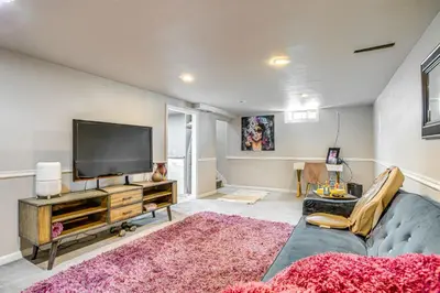 a living room with a couch and a flat screen tv at 6 Mi to Dtwn Denver Escape with Fire Pit in Denver