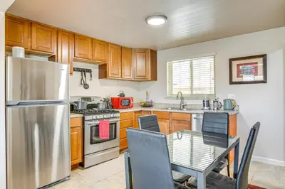 a kitchen with a stainless steel refrigerator and a table at 6 Mi to Dtwn Denver Escape with Fire Pit in Denver