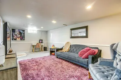 a living room with a blue couch and a pink rug at 6 Mi to Dtwn Denver Escape with Fire Pit in Denver