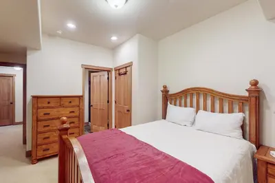 a bedroom with a wooden bed and a dresser at Rendezvous Royalty in Fraser