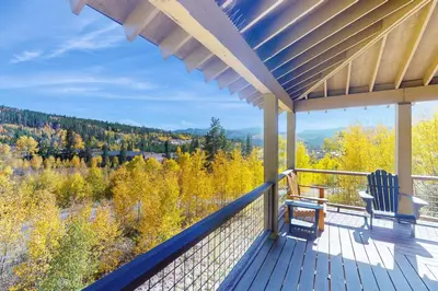 a porch with a bench and a view of the mountains at Rendezvous Royalty in Fraser