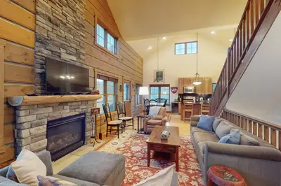 a living room with a fireplace and a tv at Rendezvous Royalty in Fraser