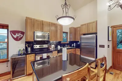a kitchen with wooden cabinets and stainless steel appliances at Rendezvous Royalty in Fraser