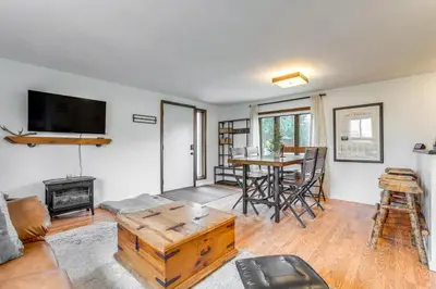 a living room with a table and a fireplace at Hike, Ski and More Walkable Downtown Granby Home in Granby