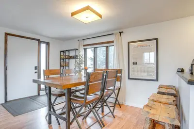 a dining room with a wooden table and chairs at Hike, Ski and More Walkable Downtown Granby Home in Granby