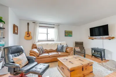 a living room with a leather couch and a tv at Hike, Ski and More Walkable Downtown Granby Home in Granby