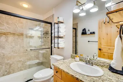 a bathroom with a toilet and a sink and a shower at Downtown WP Condo with Pool Steps to Concert Venue! in Winter Park