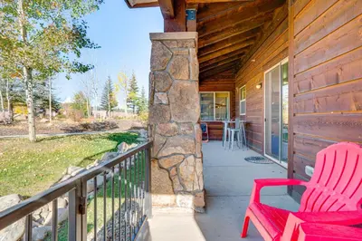 a porch with two red chairs on a house at Downtown WP Condo with Pool Steps to Concert Venue! in Winter Park