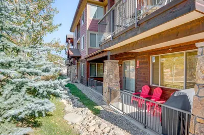 a house with red chairs on the balcony at Downtown WP Condo with Pool Steps to Concert Venue! in Winter Park