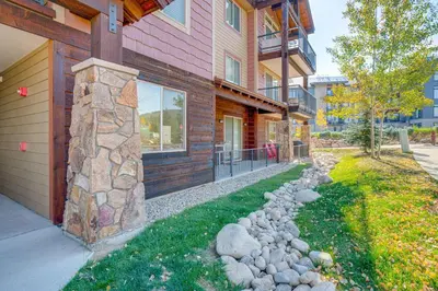 a house with a stone pillar next to a yard at Downtown WP Condo with Pool Steps to Concert Venue! in Winter Park