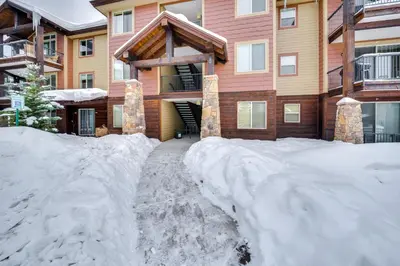 a house with a pile of snow in front of it at Downtown WP Condo with Pool Steps to Concert Venue! in Winter Park