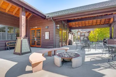 a patio with a bench and a fire pit on a building at Downtown WP Condo with Pool Steps to Concert Venue! in Winter Park