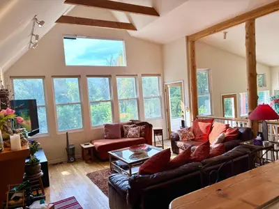 a living room with a couch and a table at Creekside Craftsman Cabin with Jacuzzi - Alpine Splendor 6 Mins to downtown in Boulder