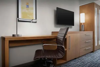 a desk with a chair and a television on a wall at Hyatt Place Boulder Pearl Street - Newly Renovated in Boulder