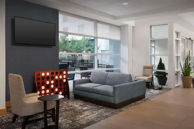 a living room with a couch and chairs and a tv at Hyatt Place Boulder Pearl Street - Newly Renovated in Boulder