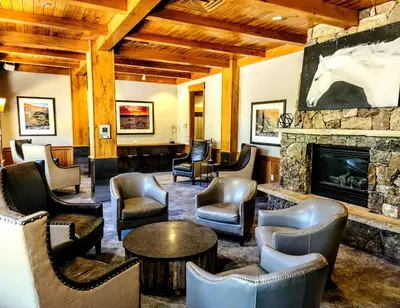 a lobby with chairs tables and a fireplace at Ski-In Ski-Out Condo at Zephyr Mountain Lodge 1518 in Winter Park