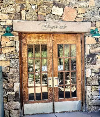 a stone building with a wooden door and windows at Ski-In Ski-Out Condo at Zephyr Mountain Lodge 1518 in Winter Park