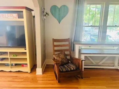 a living room with a chair and a tv at Walk to Dining Breweries and Shops Plus New Hot Tub in Louisville