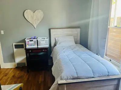 a bedroom with a bed and a table with a heart on the wall at Walk to Dining Breweries and Shops Plus New Hot Tub in Louisville