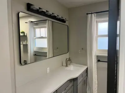 a bathroom with a white sink and a mirror at Walk to Dining Breweries and Shops Plus New Hot Tub in Louisville