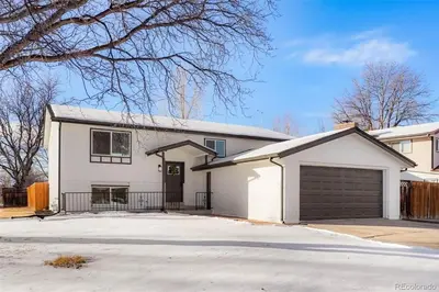 a white house with a garage at Spacious and Cozy 5 Bed 3 Bath Vacation House W 2 King 3 Queen! Sleep 12! 15Min to Red Rocks in Arvada