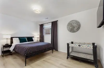 a bedroom with a bed and a clock on the wall at Spacious and Cozy 5 Bed 3 Bath Vacation House W 2 King 3 Queen! Sleep 12! 15Min to Red Rocks in Arvada