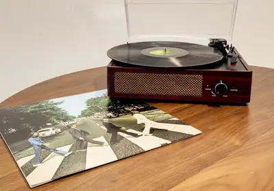 an old record player sitting on a table with a vinyl record at Spacious and Cozy 5 Bed 3 Bath Vacation House W 2 King 3 Queen! Sleep 12! 15Min to Red Rocks in Arvada