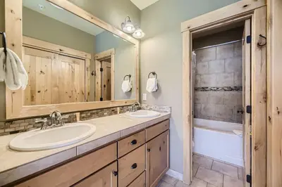 a bathroom with two sinks and a mirror and a tub at 6507 Settlers Creek Townhomes townhouse in Keystone