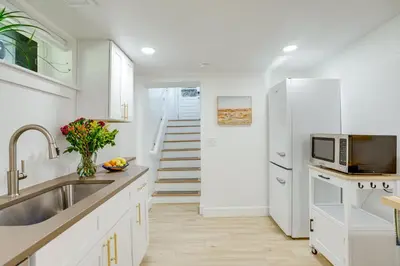 a white kitchen with a sink and a refrigerator at Steps from Wash Park Modern Apt, Patio and Parking in Denver