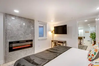 a bedroom with a bed and a fireplace at Steps from Wash Park Modern Apt, Patio and Parking in Denver
