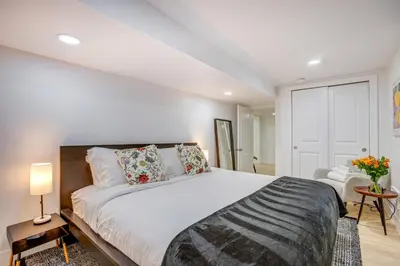 a bedroom with a large white bed with pillows at Steps from Wash Park Modern Apt, Patio and Parking in Denver