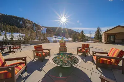 a patio with chairs and a table with a fire pit at Slopeside 2730A by SummitCove Lodging in Keystone