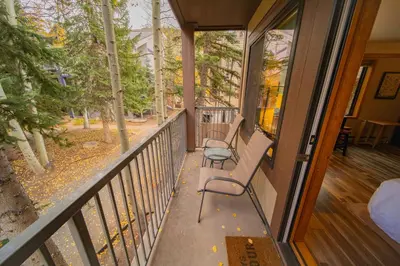a balcony with two chairs on a porch at Slopeside 2730A by SummitCove Lodging in Keystone