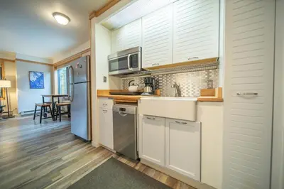 a kitchen with white cabinets and stainless steel appliances at Slopeside 2730A by SummitCove Lodging in Keystone