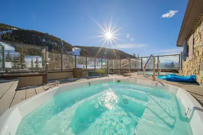 a hot tub on a deck with a view at Slopeside 2730A by SummitCove Lodging in Keystone