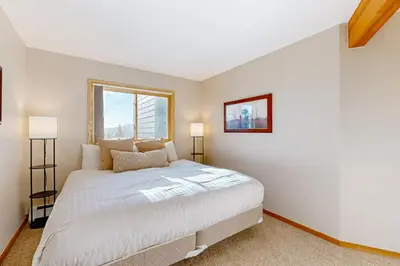a bedroom with a large white bed and a window at Snowscape Modern Mountain Retreat in Silverthorne
