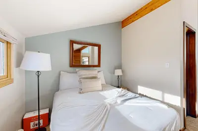 a bedroom with a white bed and a mirror at Snowscape Modern Mountain Retreat in Silverthorne