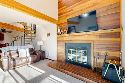 a living room with a fireplace and a tv on a wall at Snowscape Modern Mountain Retreat in Silverthorne