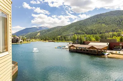 a view of a lake with a building and a fountain at 1483 Lakeside condo in Keystone