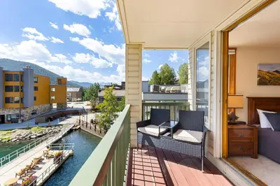 a balcony with two chairs and a view of a river at 1483 Lakeside condo in Keystone