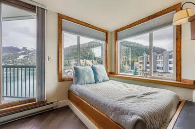 a bedroom with a bed and two windows at 1483 Lakeside condo in Keystone